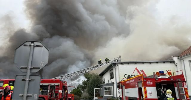 Hasiči stále zasahují u požáru hal u Prahy, škoda přesáhne 100 milionů