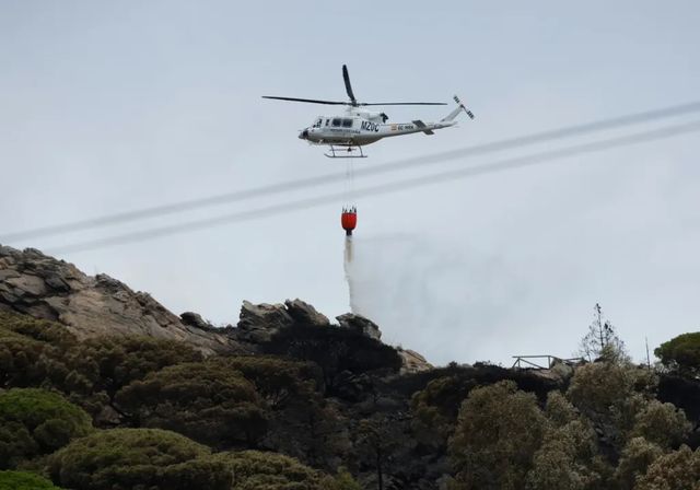 El viento cambiante e intenso mantiene vivo el incendio forestal de Tarifa