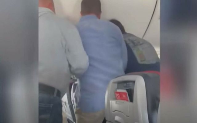 Momentul în care un pasager încearcă să deschidă ușa unui avion în timpul zborului. Aeronava a aterizat de urgență