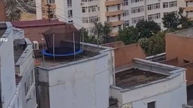 Un copil, surprins în timp ce sărea pe o trambulină instalată pe acoperișul unui bloc din Capitală