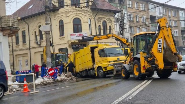 Momentul în care o mașină de gunoi este „înghițită” de o groapă apărută în asfalt, în centrul orașului Galați