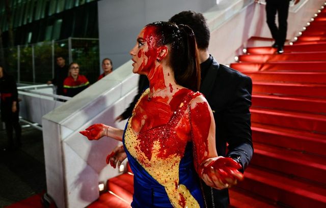 O femeie îmbrăcată în culorile Ucrainei s-a acoperit cu sânge fals pe covorul roșu al festivalului de la Cannes