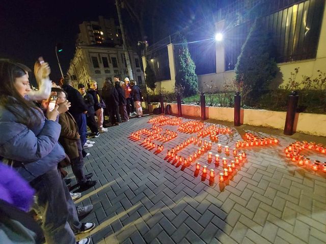 Десятки людей возлагают цветы и зажигают свечи перед зданием Посольства России в Кишиневе в память о погибших в Крокус Сити Холле